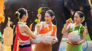 Personas celebrando Songkran, el Año Nuevo tailandés, con agua y flores durante el festival tradicional de Tailandia.