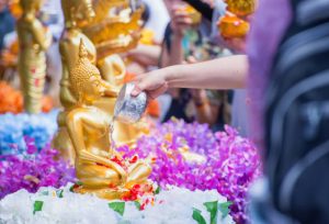 Personas celebrando Songkran, el Año Nuevo tailandés, con agua y flores durante el festival tradicional de Tailandia.